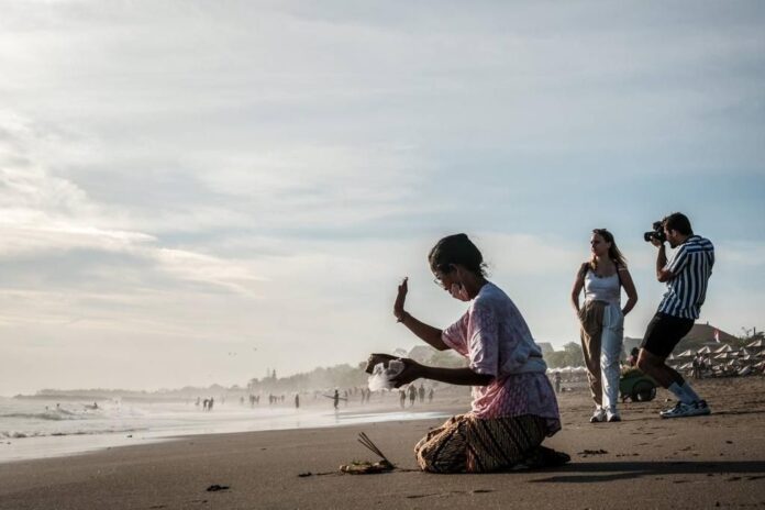 FOTO Seorang warga Bali tengah berdoa di salah satu pantai yang banyak dikunjungi wisatawan_dok. kemanparekraf